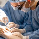 surgeons performing surgical operation on a patient’s knee surgeons performing surgical operation on a patient's knee