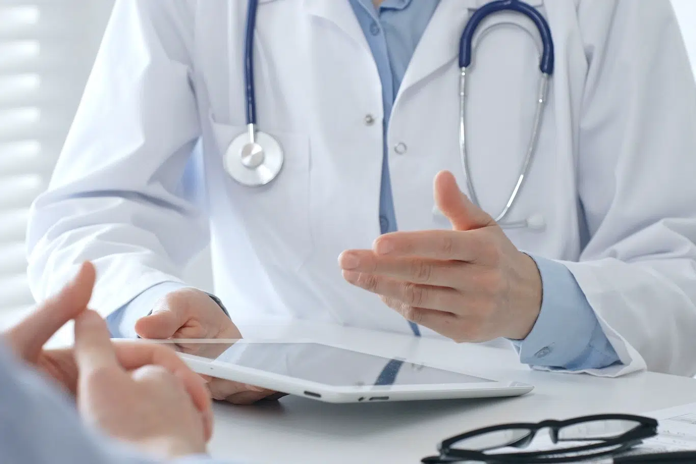 doctor consulting patient with tablet in modern office