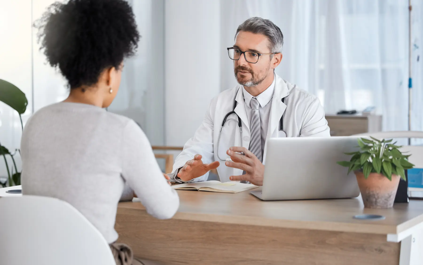 Doctor consulting with patient in office, discussing treatment options.